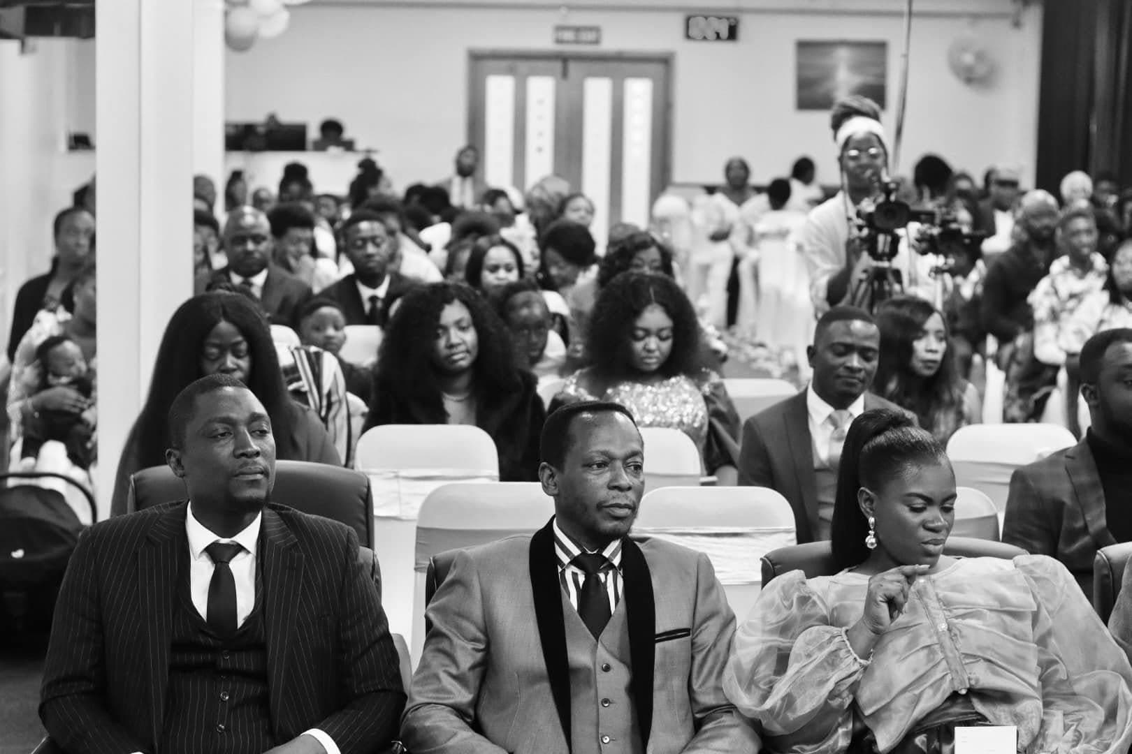 The congregation listening during a Sunday service, photographed in black and white