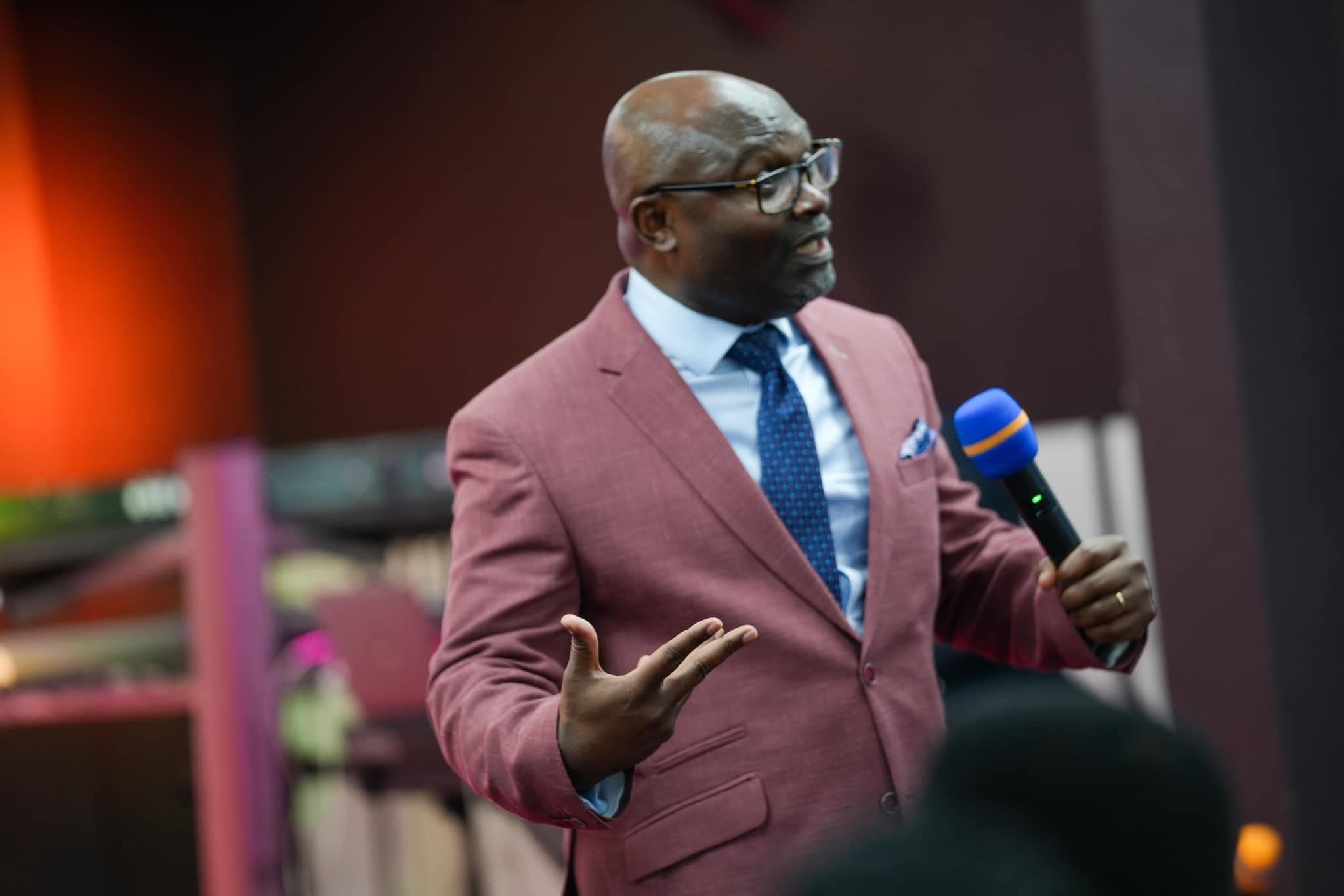 Pastor preaching mid-sermon, microphone in hand